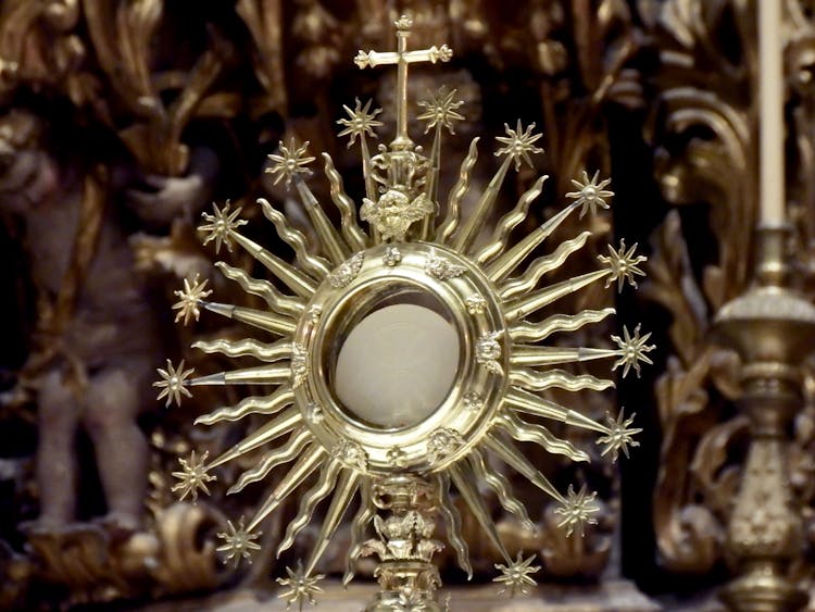 Golden Monstrance Against Blurred Church Interior