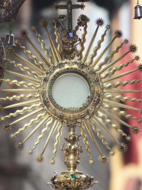 Beautifully adorned sun shaped golden ostensory with Eucharistic host