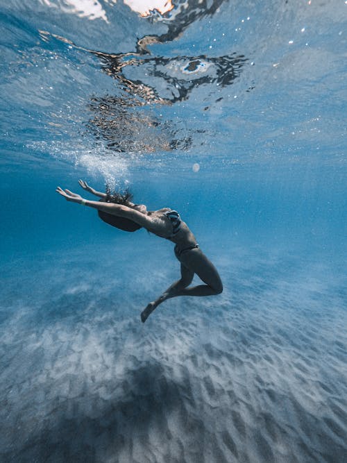 Woman in Black Bikini Swimming Underwater