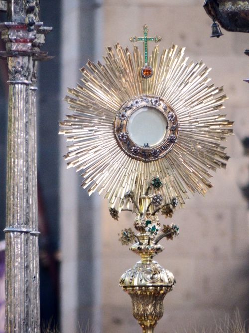 Free Beautifully adorned golden monstrance in shape of sunburst during Catholic procession in street Stock Photo