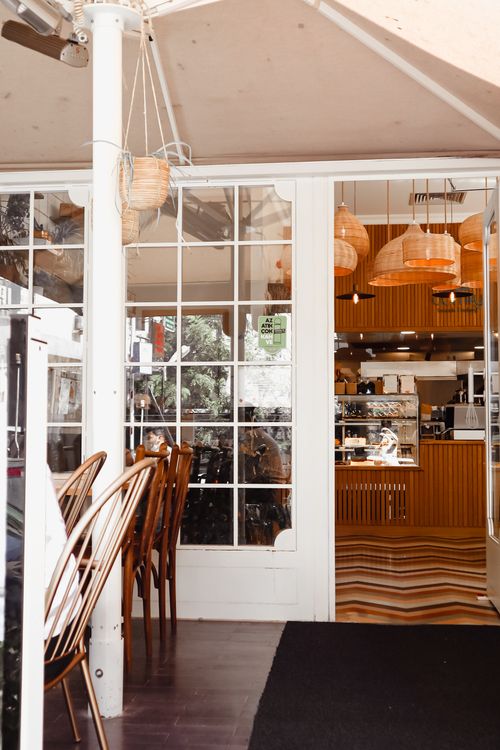 Free Inviting restaurant entrance showcasing stylish interior with rattan lights and wooden furniture. Perfect for dining out concepts. Stock Photo
