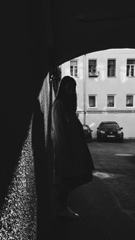 Moody silhouette of a person under an archway in Moscow street, highlighting contrast.