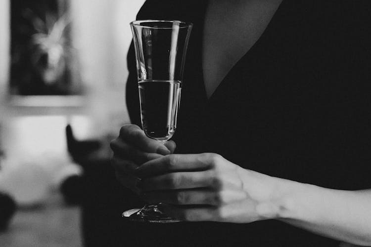 Grayscale Photo Of A Person's Hands Holding A Glass