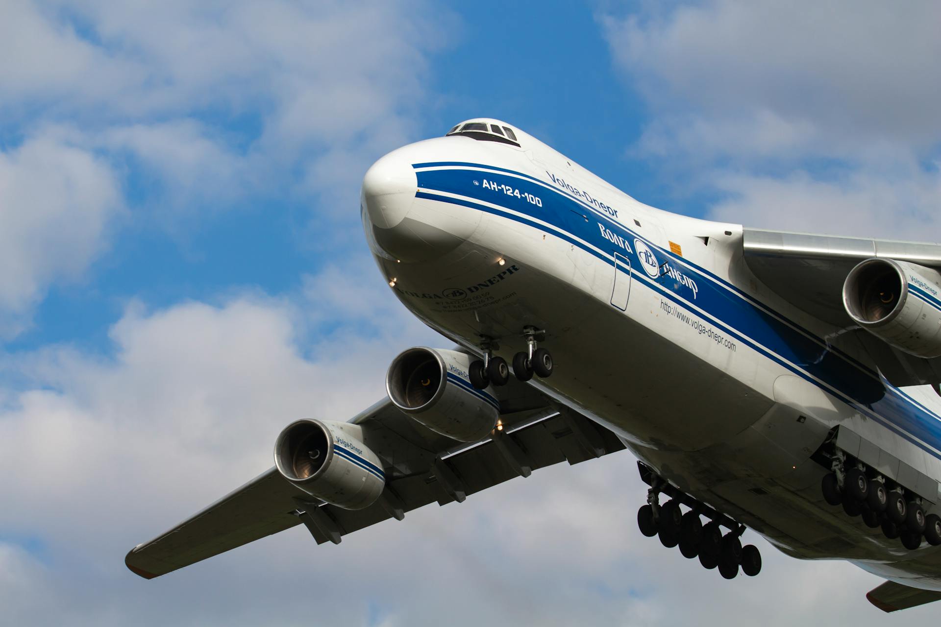 Antonov AN-124 cargo plane in flight with cloudy sky background in Budapest.