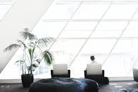 这间宽敞的现代休息室采用极简主义装饰，配有大窗户和时尚座椅