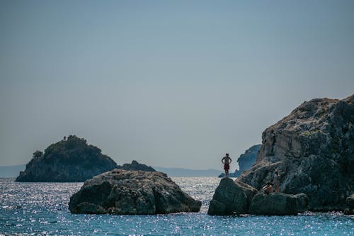 A Shirtless Man Standing on a Rock