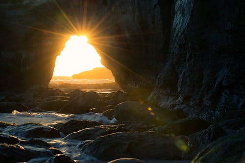 Free Cave Near Body of Water at Sunset Stock Photo