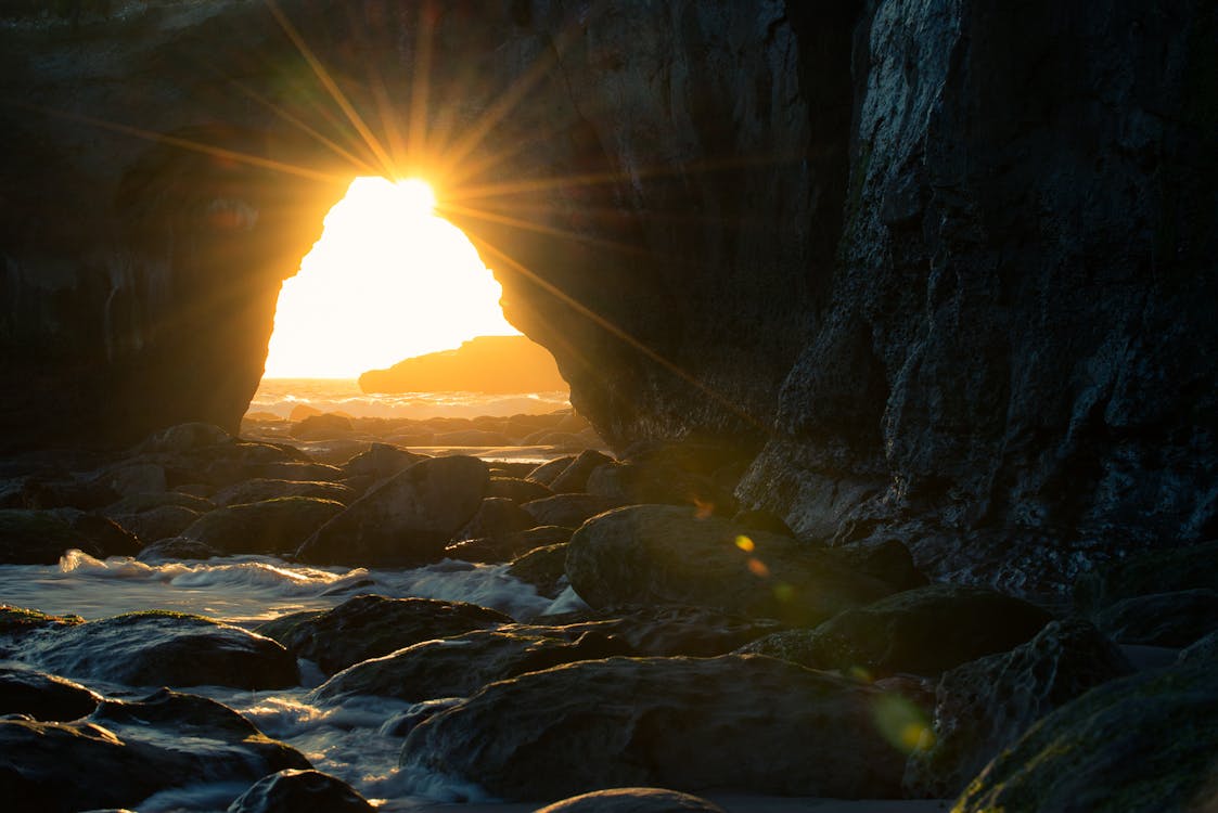Free Cave Near Body of Water at Sunset Stock Photo