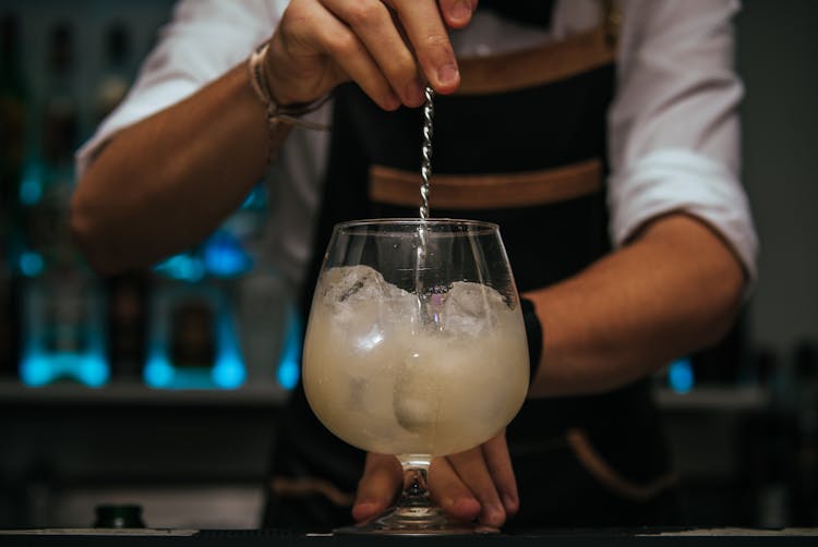 A Person Stirring A Cocktail Drink