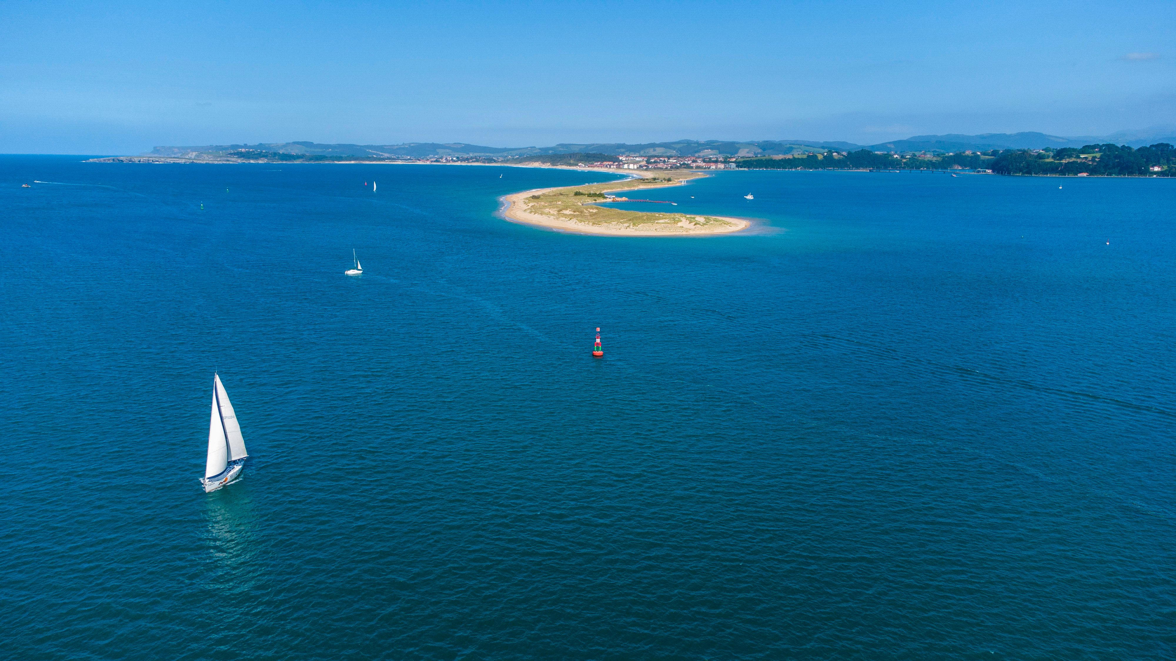 Amazing Barcelona Unique Private Luxury Sailing Tour (max 12 people) Review: A Luxurious Mediterranean Escape Worth Every Euro Review 2026 - A stunning aerial view of a sailboat navigating the blue waters near a scenic island in Spain.
