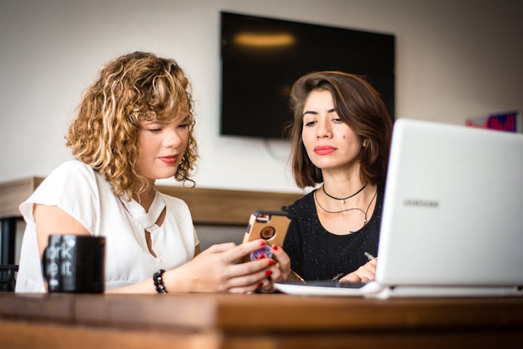 Photo Of Women Looking At A Cell Phone