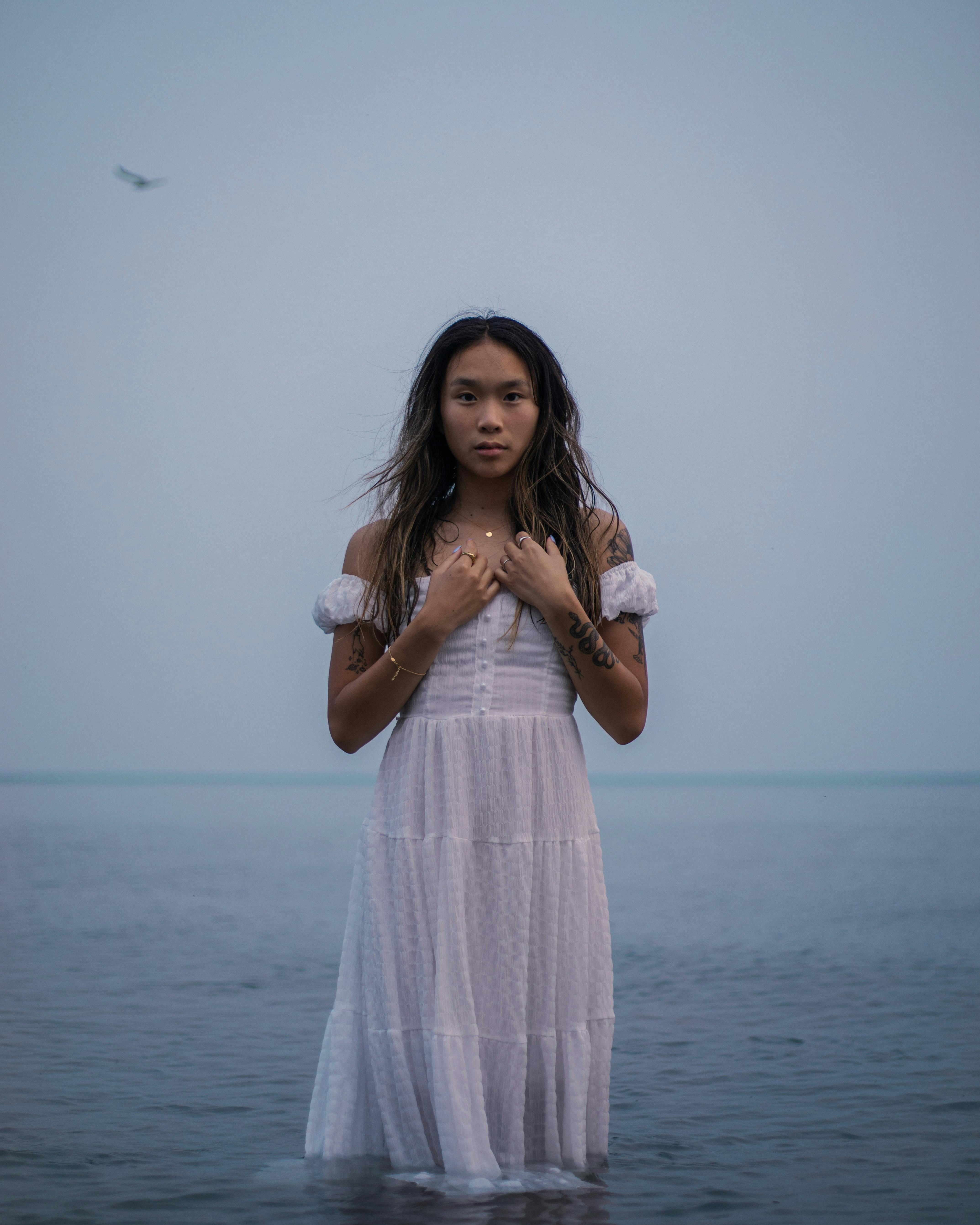 一个女人在海上的白色连衣裙的宁静的晚上肖像