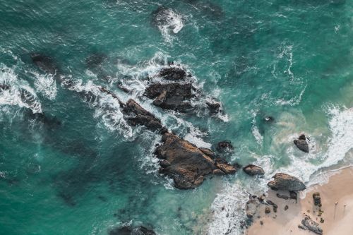 Free Stunning aerial view of Laguna Beach with rocky coastline and turquoise ocean waves. Stock Photo