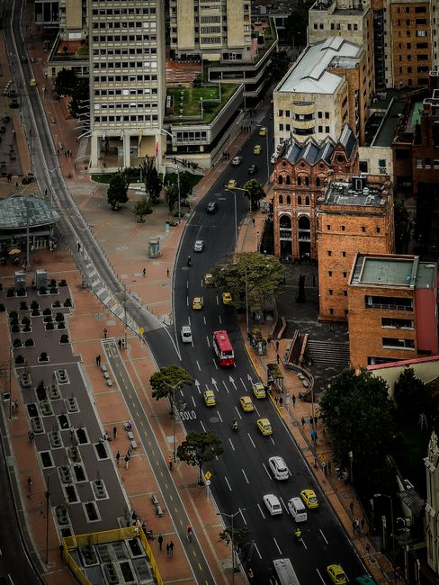 A bustling cityscape of Bogotá featuring streets, buildings, and vehicles from above.