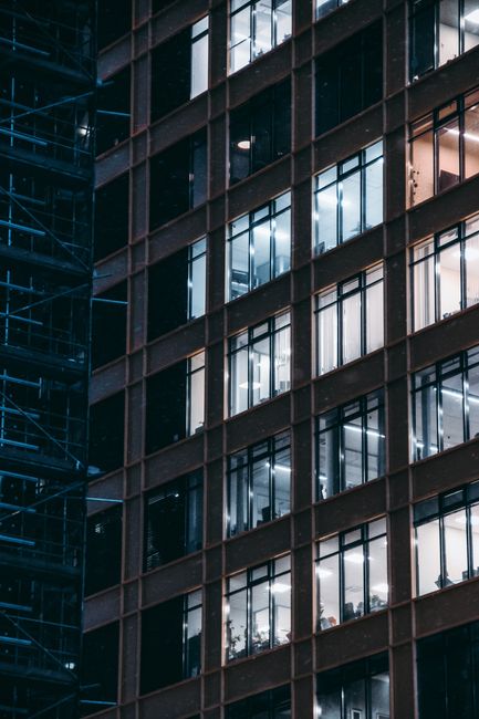 Close-up of a modern office building with illuminated windows at night, showcasing urban architecture.