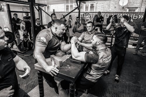 People Watching on Two Men Doing Arm Wrestling