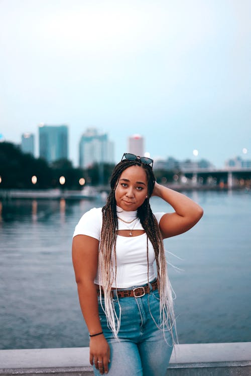 A Woman with Long Braided Hair while Wearing a White Top and Jeans