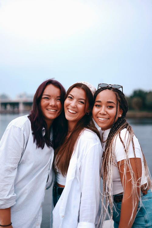 Women Wearing White Tops while Smiling Together