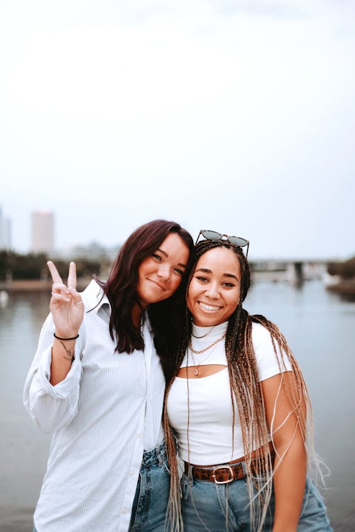 Woman Doing the Peace Sign Beside Her Friend