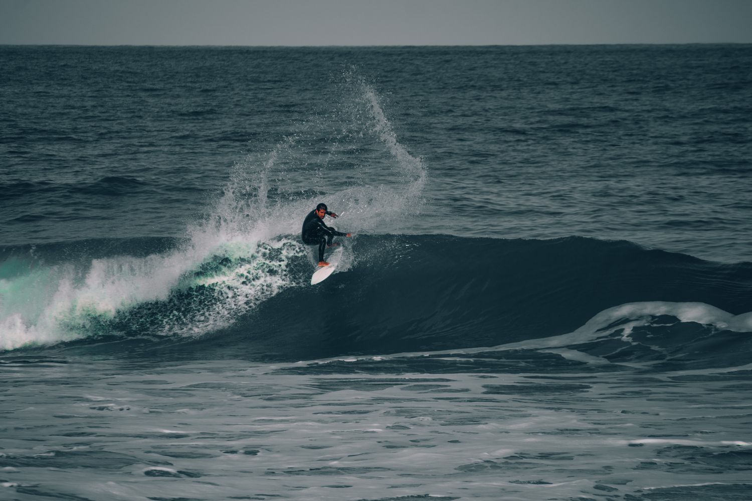 A surfer riding clear blue ocean waves