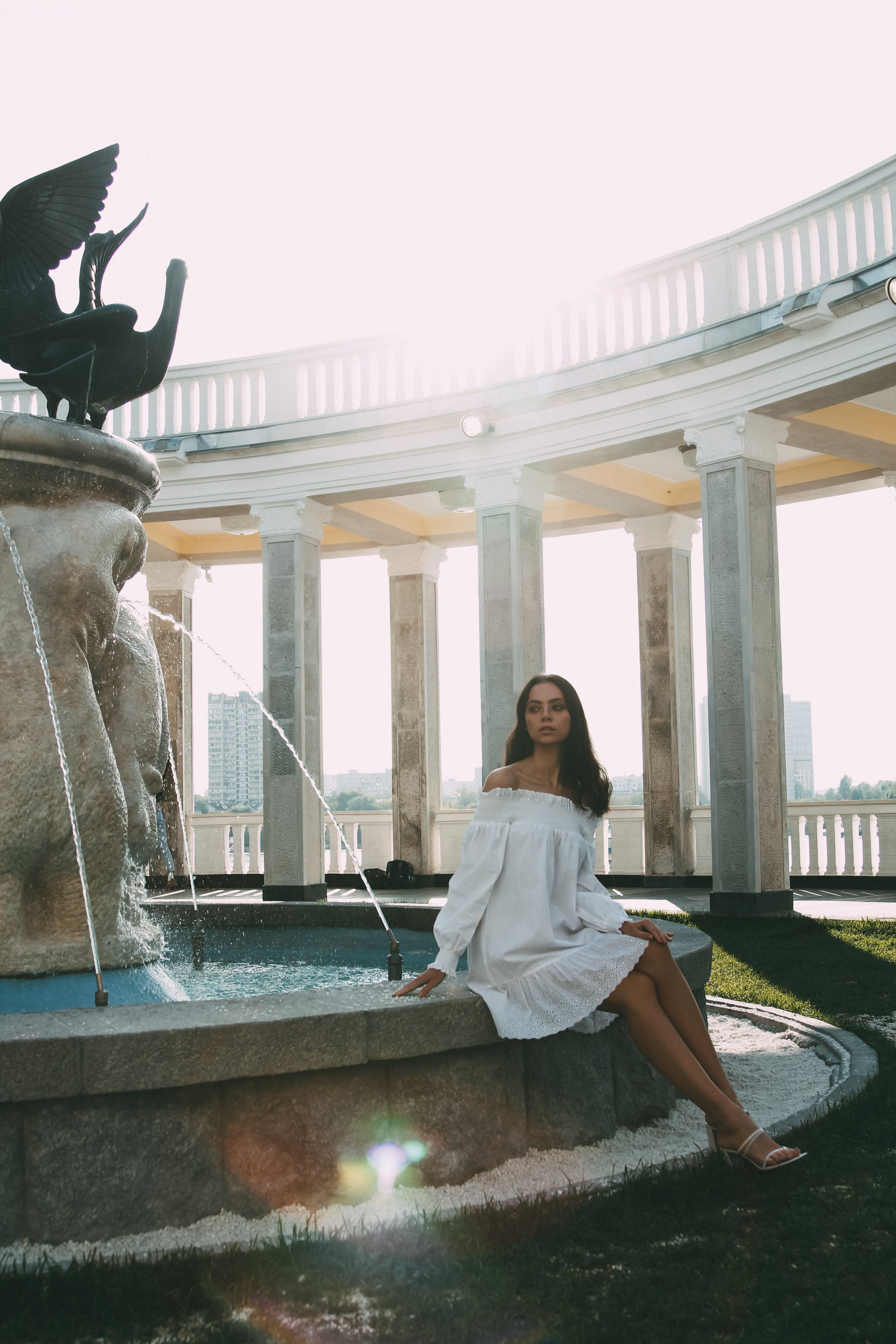 A Woman Sitting Near a Water Fountain · Free Stock Photo