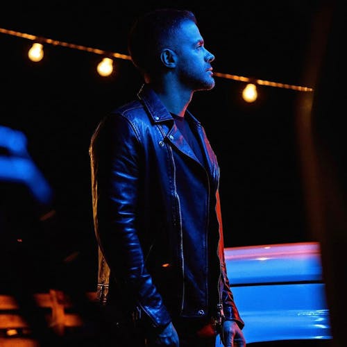 Man in a Leather Jacket Illuminated by a Blue Light