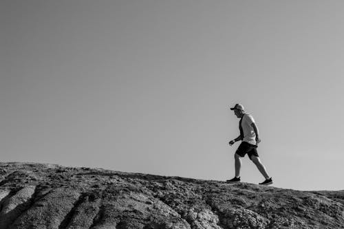 Free A Man Walking on a Rock Formation Stock Photo