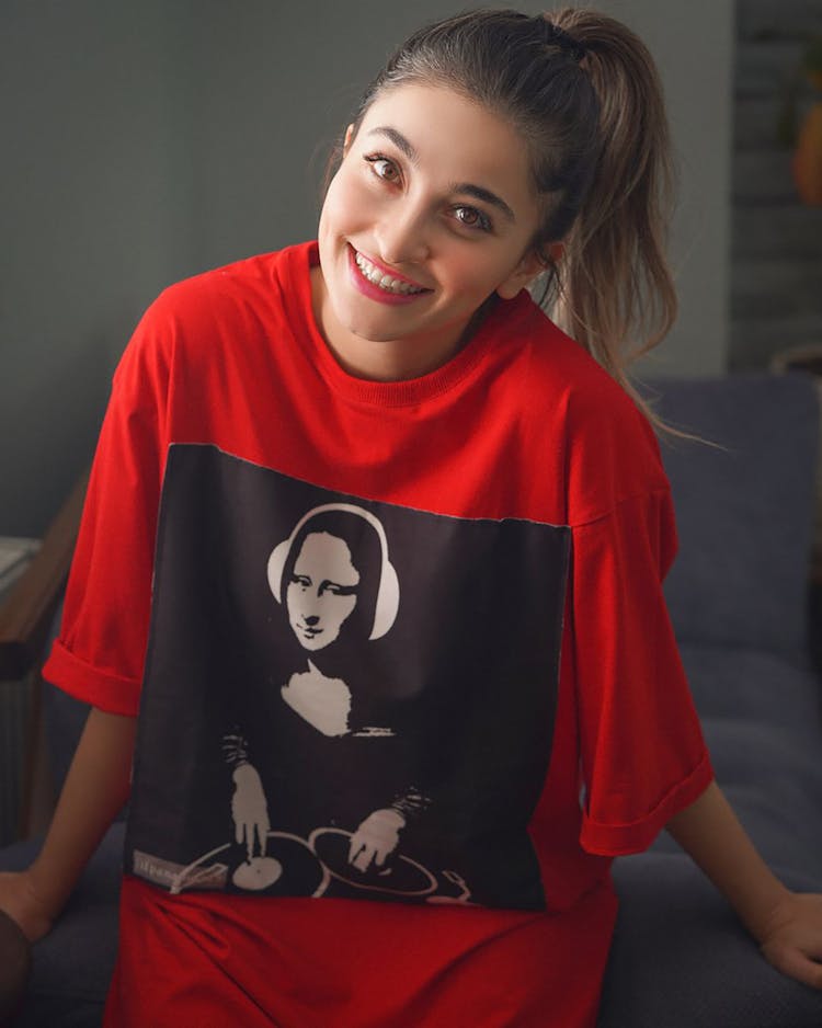 A Woman Smiling While Wearing An Oversized Shirt