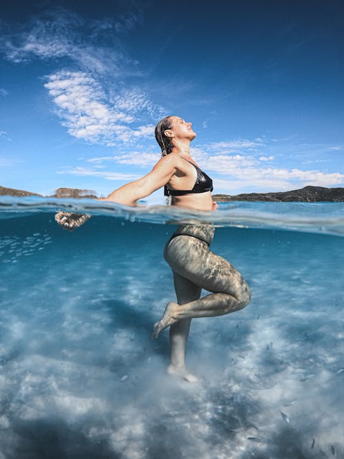 A Woman Standing Underwater while Wearing a Bikini