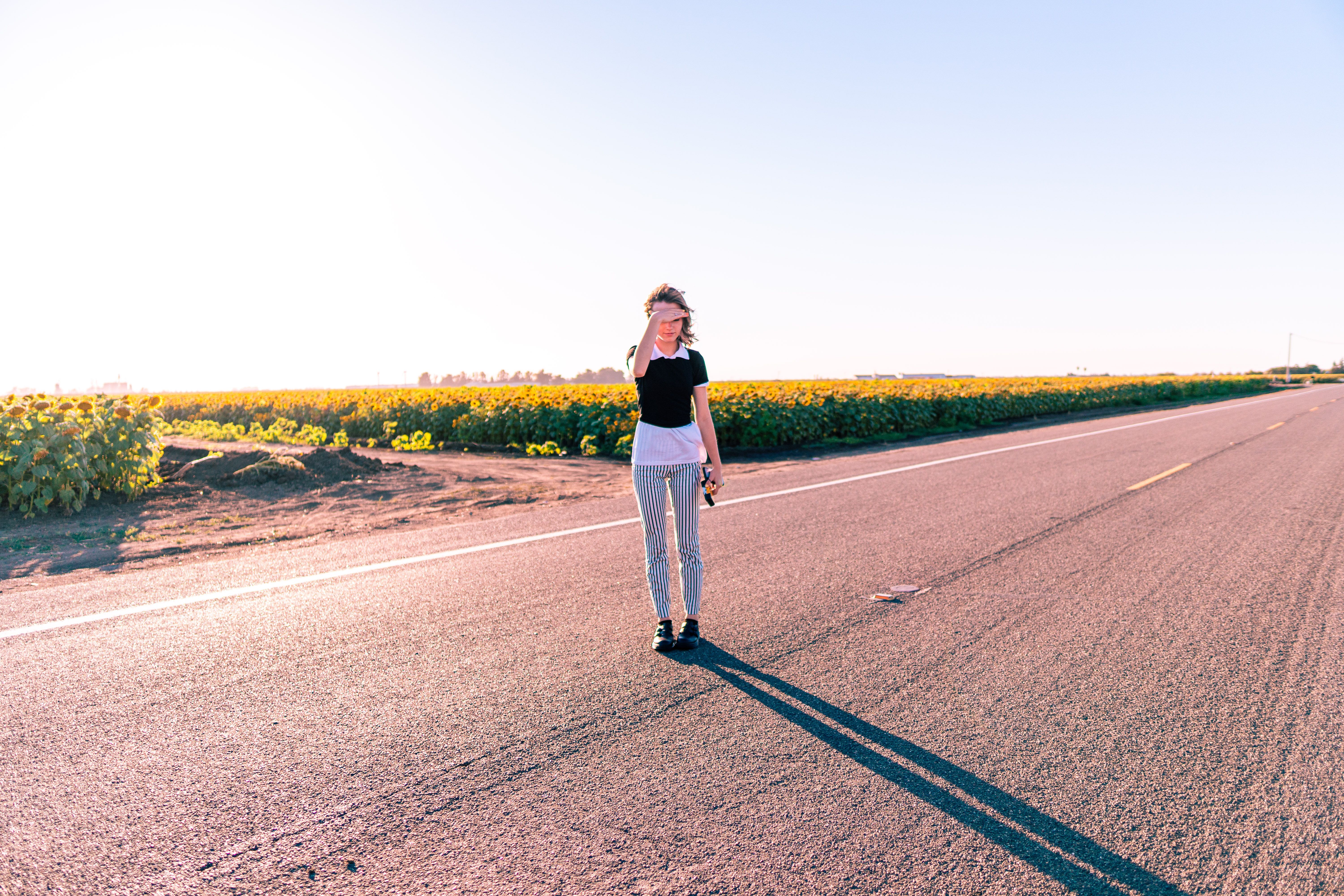 A Woman Standing in the Middle of a Road · Free Stock Photo