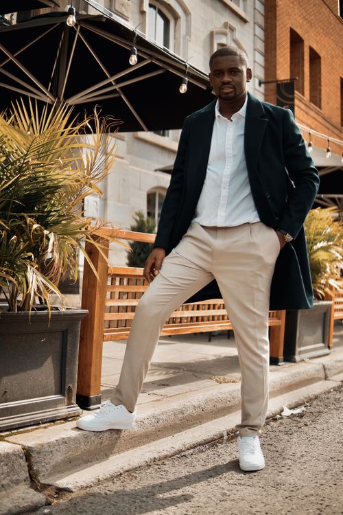 Free Fashionable man in Ottawa poses outdoors in beige pants and black coat. Urban setting. Stock Photo