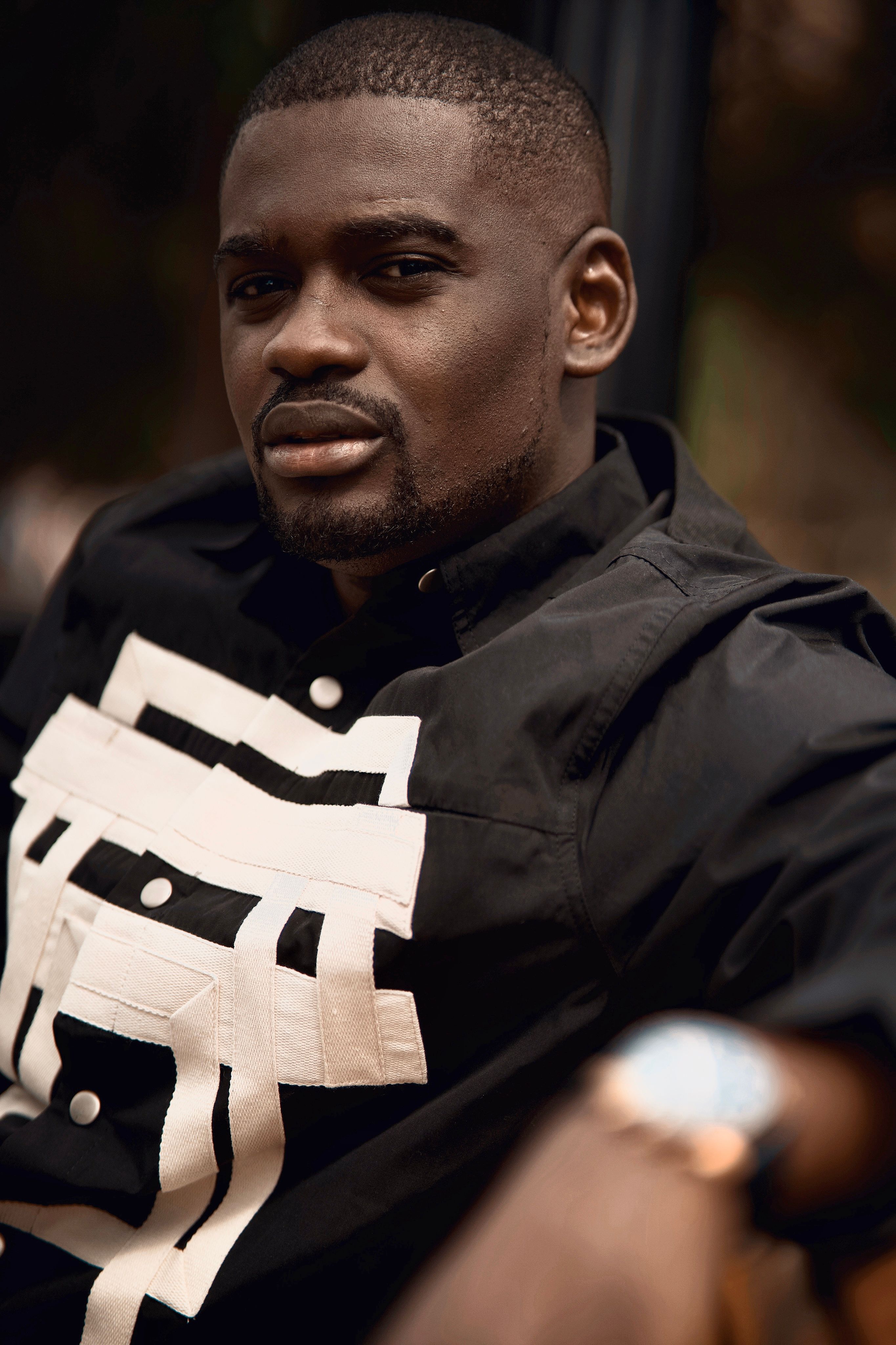 Portrait of a confident man wearing a black geometric shirt outdoors in Ottawa.