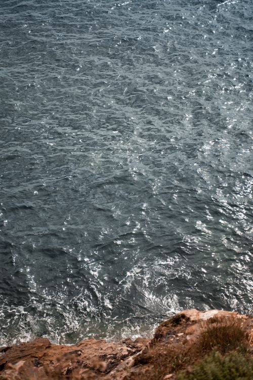 Free A captivating view of ocean waves interacting with a rocky shoreline, displaying nature's dynamic beauty. Stock Photo