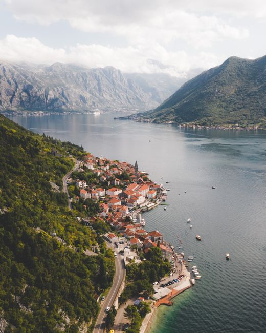 Breathtaking aerial view of charming Perast, Montenegro, along the picturesque Bay of Kotor surrounded by mountains.
