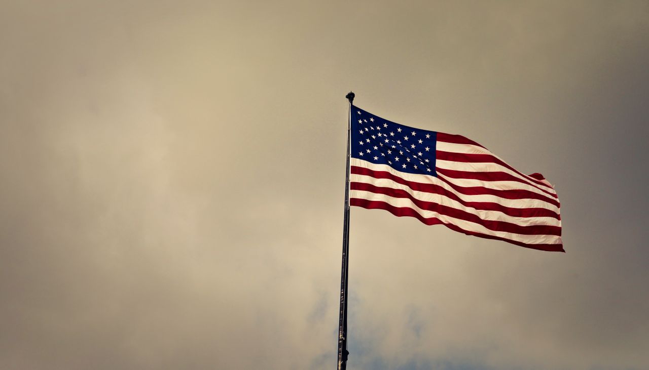 us flag waving in wind against a cloudy sky symbolizing freedom and pa