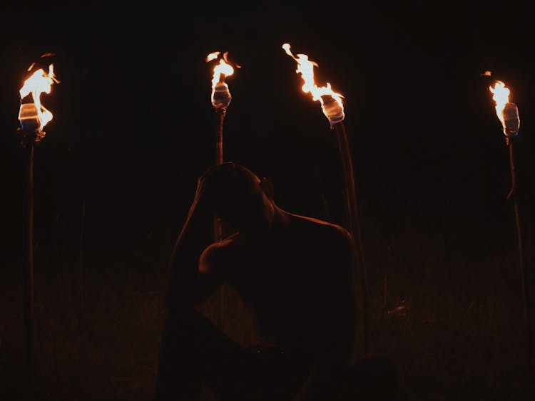 Photograph Of A Man Near Torches