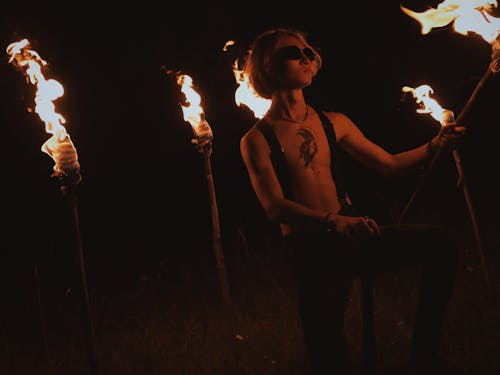 Photo of a Man with Sunglasses Holding a Torch