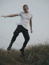 Photo of a Man in a White Shirt Jumping