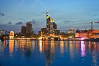 黄昏时分，法兰克福戏剧性的天际线倒映在水面上，明亮的建筑物投下充满活力的倒影