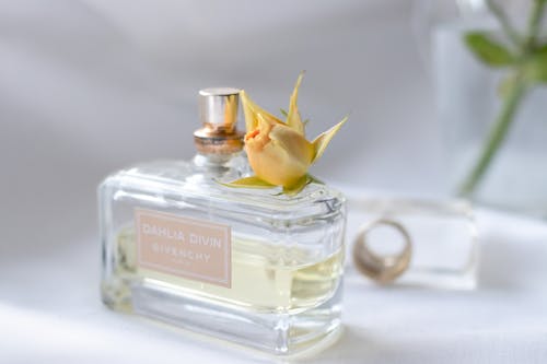 Clear Glass Perfume Bottle on White Textile