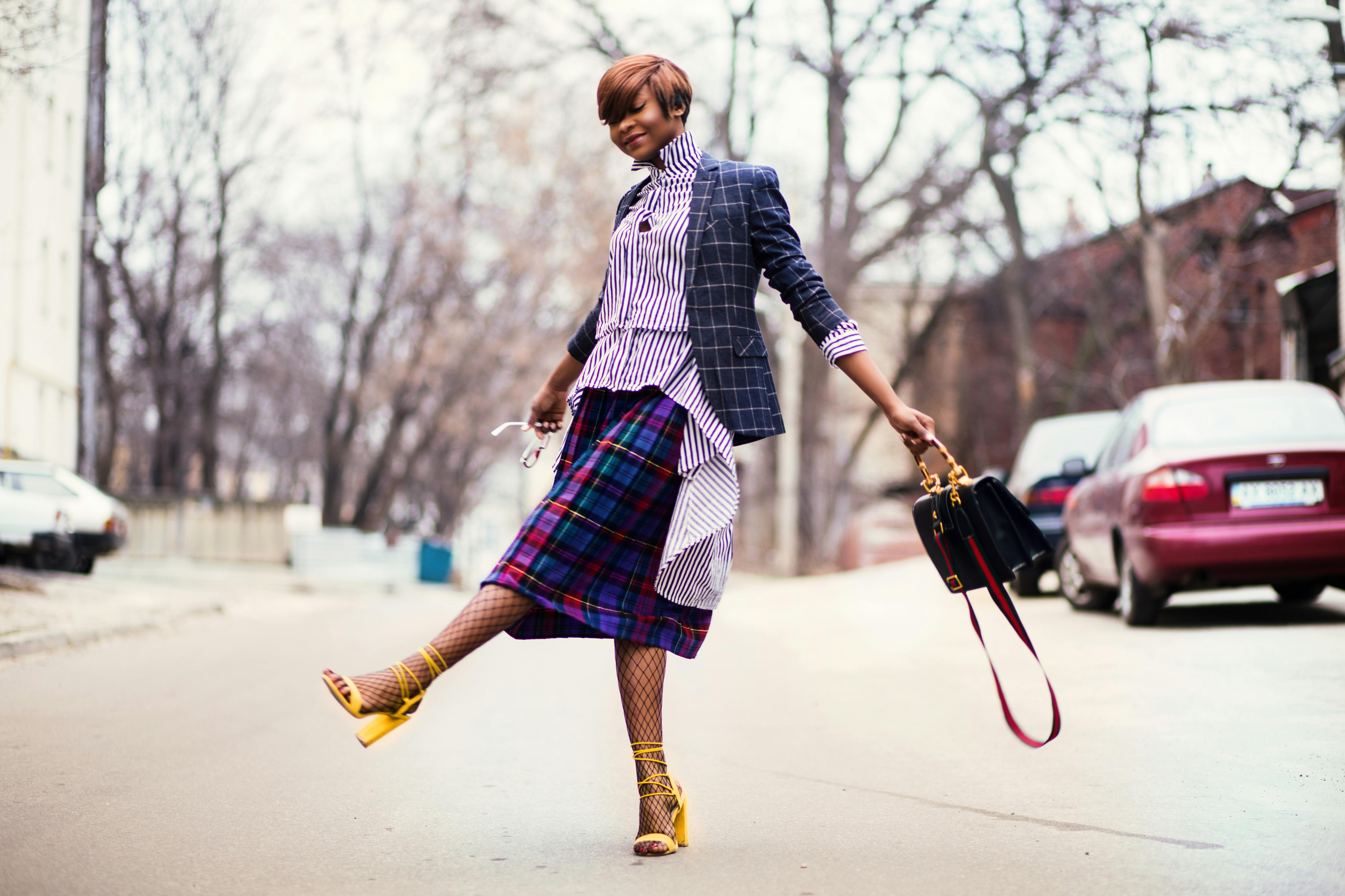 woman in purple top and plaid skirt near car