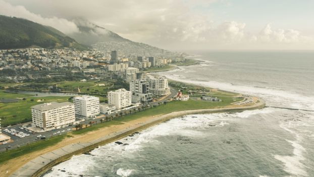 A breathtaking aerial view of Cape Town's coastline and urban landscape under a cloudy sky.