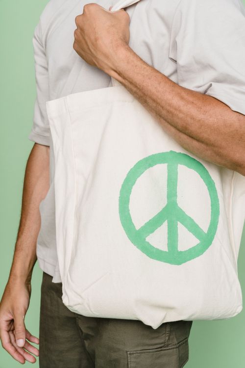 A printed cotton shoulder tote carried against a soft green wall — photo by Lara Jameson on Pexels