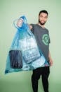 Man in Gray Crew Neck T-shirt Holding Blue Plastic Bag