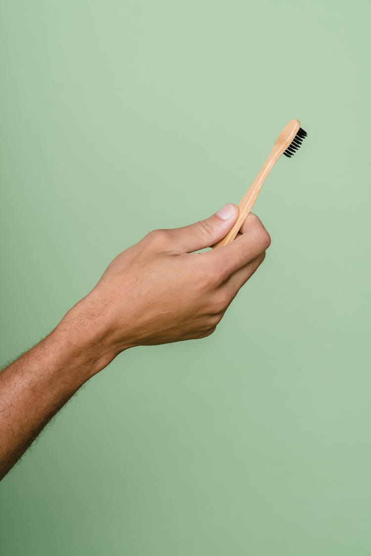 Person Holding Brown Wooden Brush