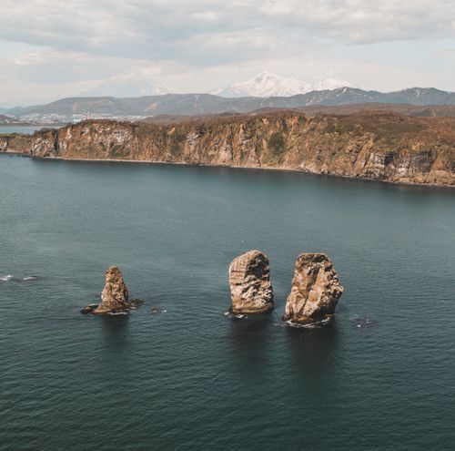 Free Stunning rock formations emerge from the sea with majestic cliffs in the background. Stock Photo