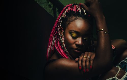 Free Striking portrait of a woman with pink braided hair and vibrant makeup, exuding confidence and style. Stock Photo