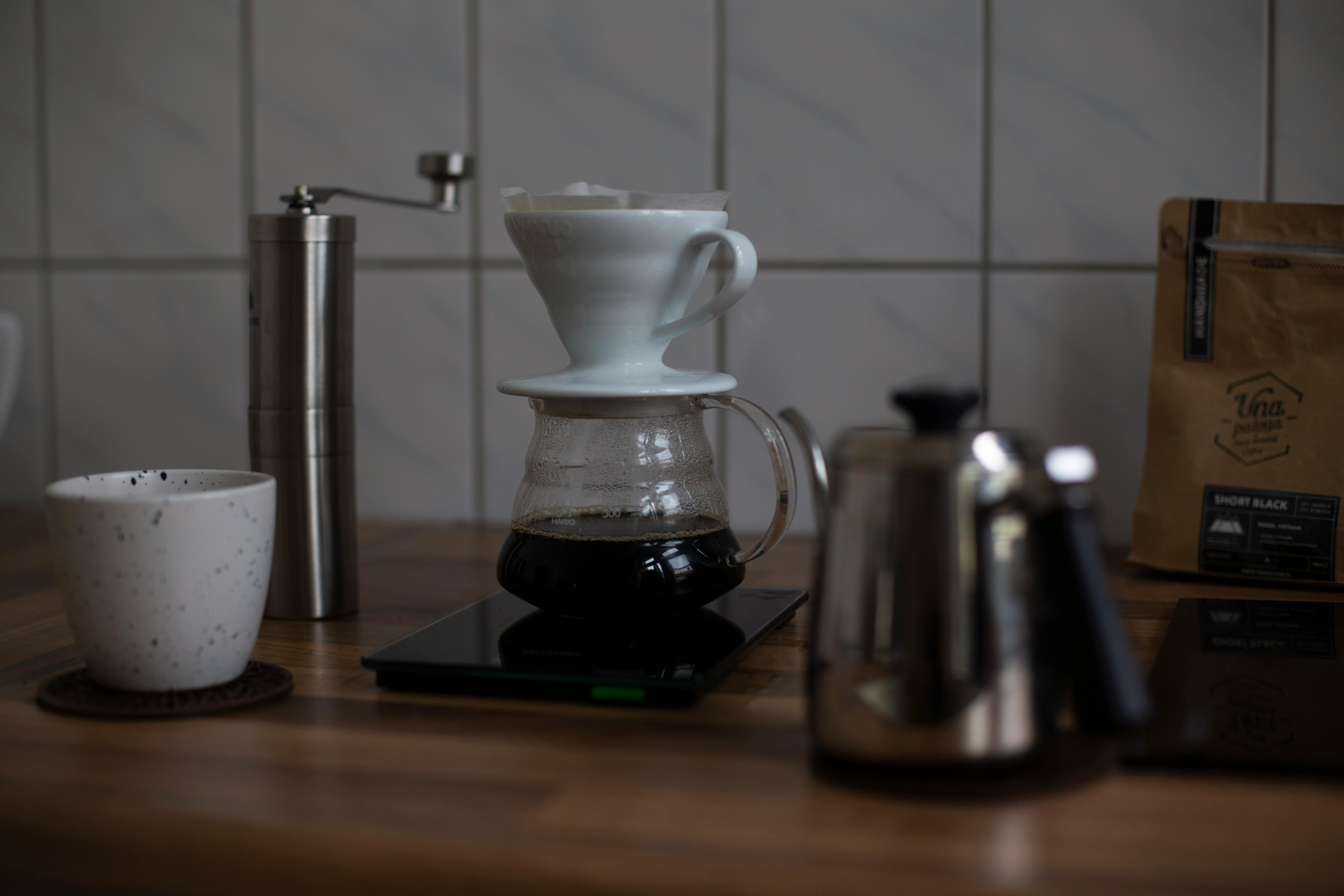 Explore a cozy coffee brewing setup with dripper and ceramic cup on a wooden surface.