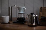 Coffee Pot on Brown Wooden Table Beside A Ceramic Cup
