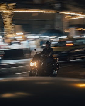 Motorcyclist riding at night with motion blur, creating a dynamic and fast-paced scene.